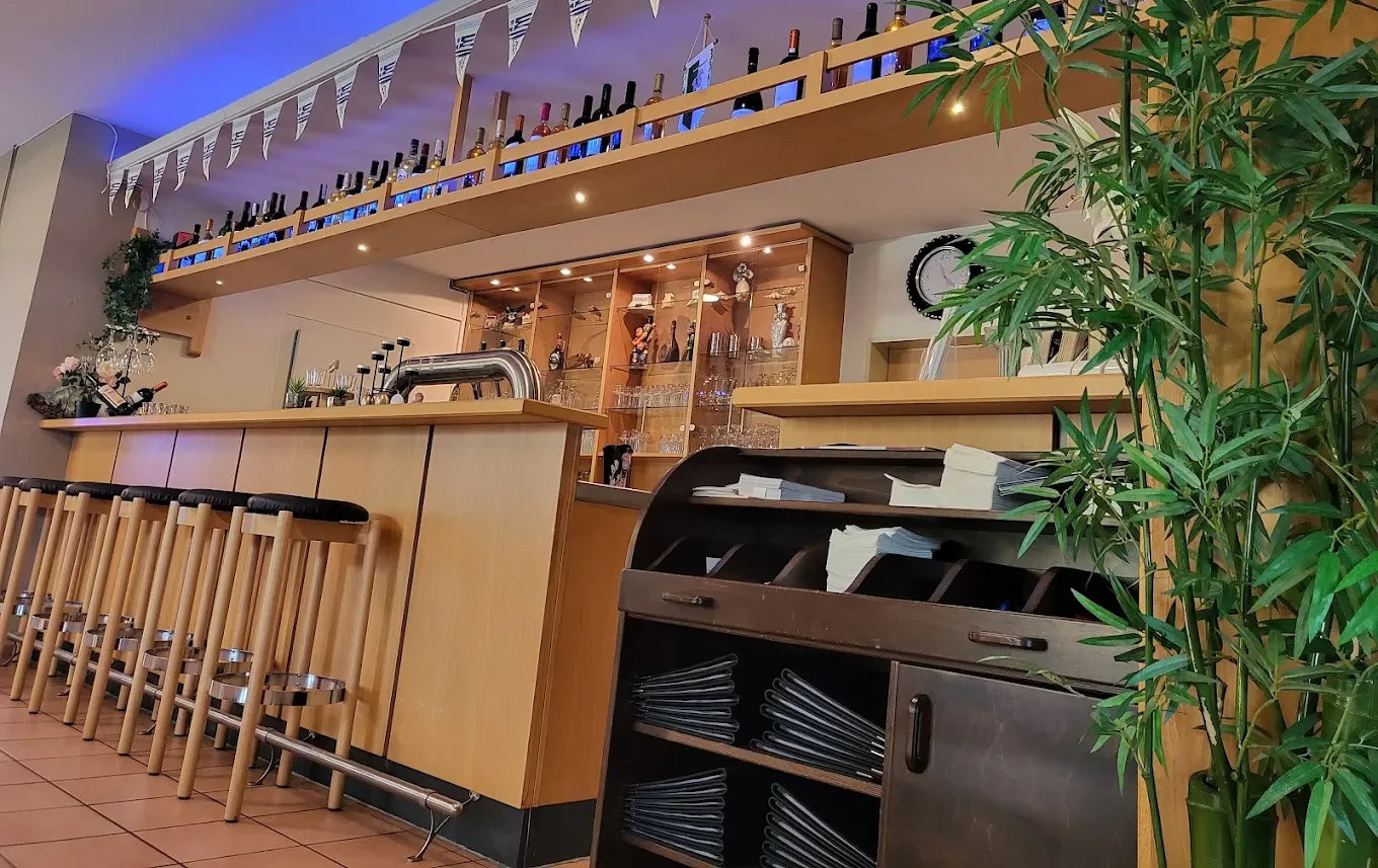 Unsere Weinbar mit einer Wand voller Flaschen, warmem Holz und gedämpftem Licht.